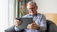  Person sitting in a chair looking at a tablet