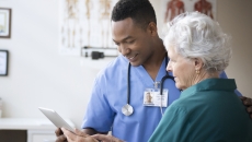   Healthcare provider showing a tablet to a patient