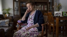 Older woman sitting in her living room pensive and depressed