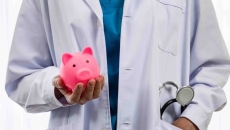 Doctor holding a piggy bank