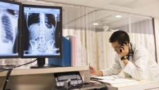 Doctor on the phone with X-ray in background