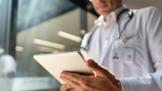 A doctor reviewing a patient's file on a digital tablet A doctor reviewing a patient's file on a digital tablet