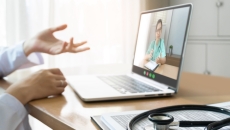 Healthcare provider on a computer talking to someone Healthcare provider on a computer talking to someone