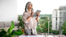 Person holding a tablet while standing on a balcony Person holding a tablet while standing on a balcony