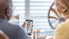 A man and a woman using a smartphone to talk to a provider A man and a woman using a smartphone to talk to a provider
