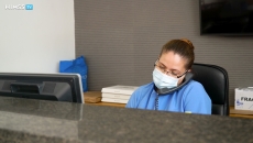 healthcare worker in mask using a phone at a desk healthcare worker in mask using a phone at a desk