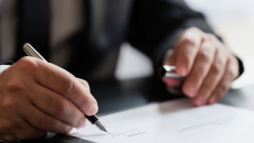Business person signing a document Business person signing a document