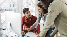 People in an office at a desk talking People in an office at a desk talking