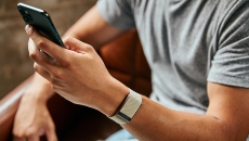 A close up of a man wearing the WHOOP 4.0 on his wrist while using a smartphone A close up of a man wearing the WHOOP 4.0 on his wrist while using a smartphone