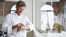 A man using a smartwatch in an office. A man using a smartwatch in an office.