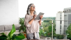 An older woman using a tablet at her desk