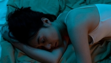 A seemingly depressed person lying in bed A seemingly depressed person lying in bed