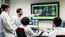 Healthcare providers sitting around a screen analyzing images