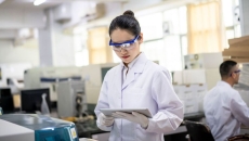 A scientist checking on results of their DNA analysis on a digital tablet A scientist checking on results of their DNA analysis on a digital tablet
