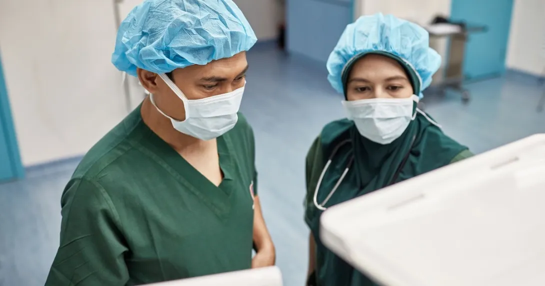 Two healthcare providers looking at computers