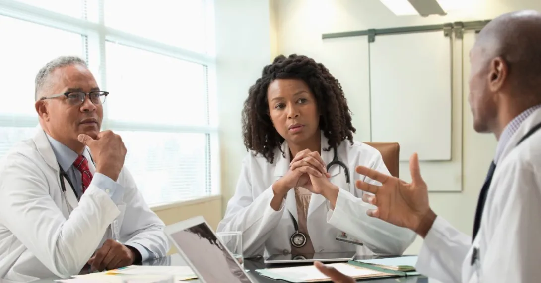 Three people sit around a table
