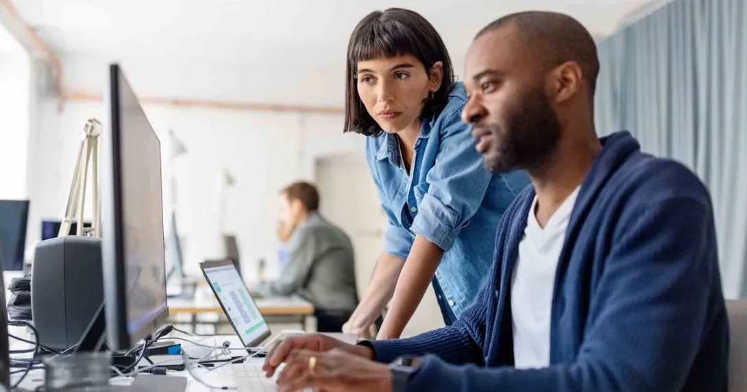 Business people looking at a desktop computer