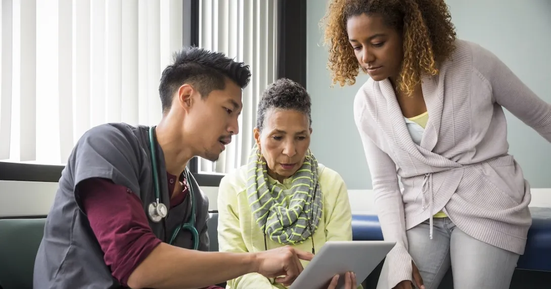 Healthcare worker consulting with a patient and family member