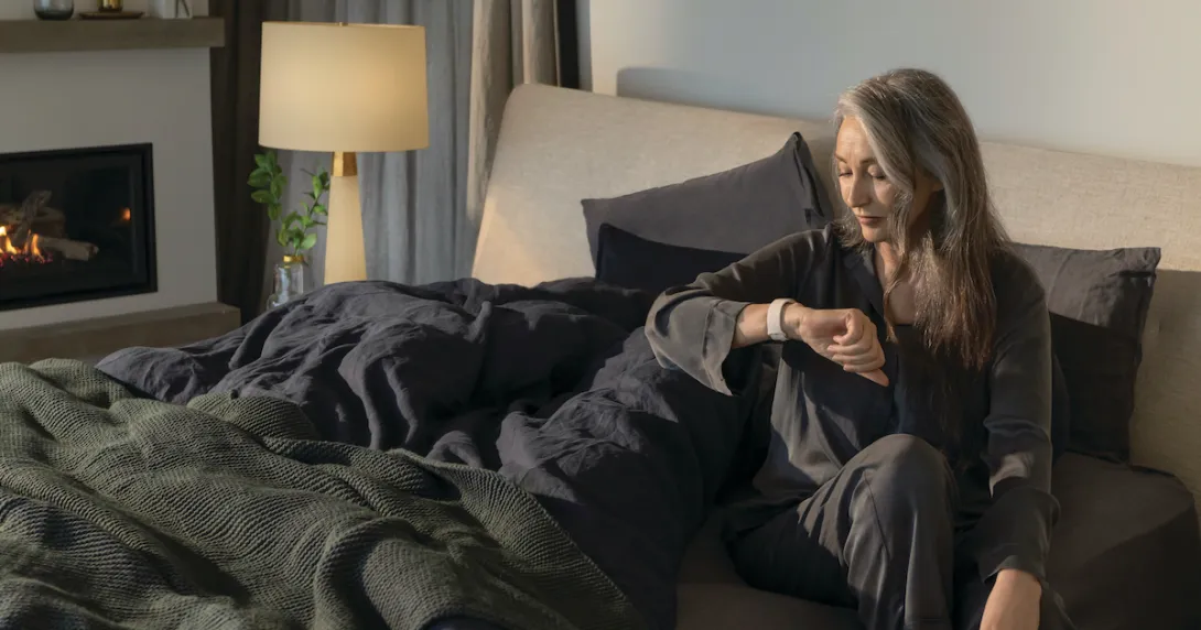 Fitbit user checks smartwatch before getting out of bed
