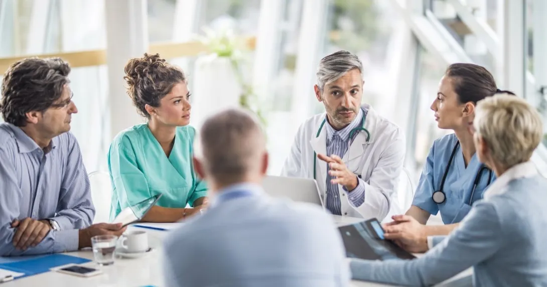 medical providers and business people sit around table