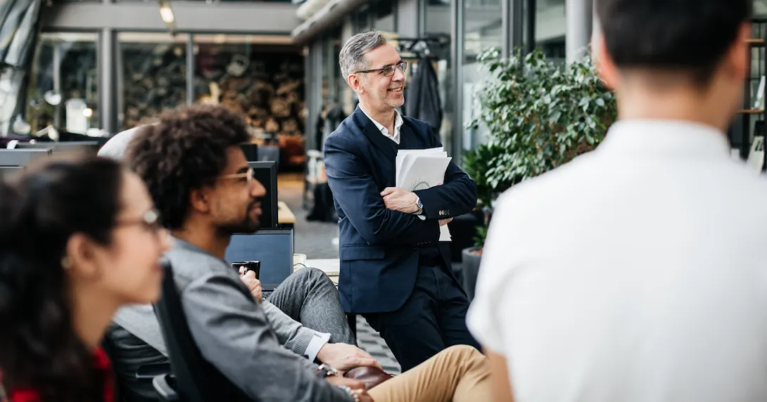 Employees sitting around and looking at something