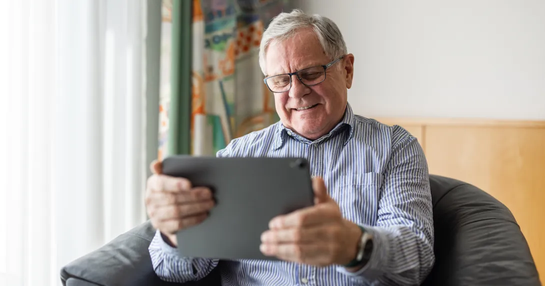 Person sitting in a chair looking at a tablet