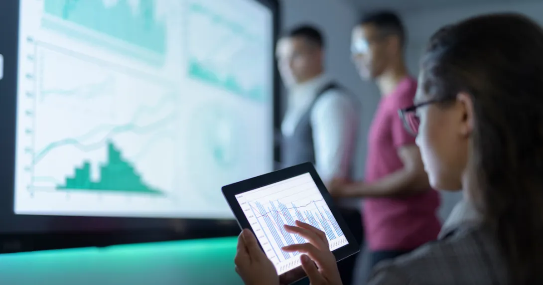 Three people in a room looking at number charts
