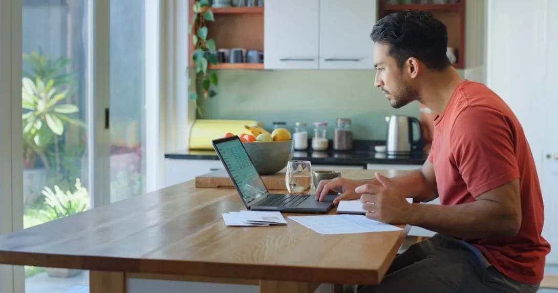 Person sitting at a table while looking at a computer