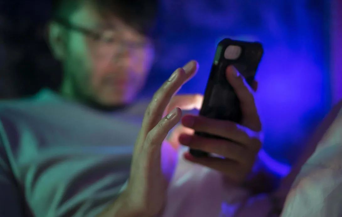 A man using a smartphone at night.