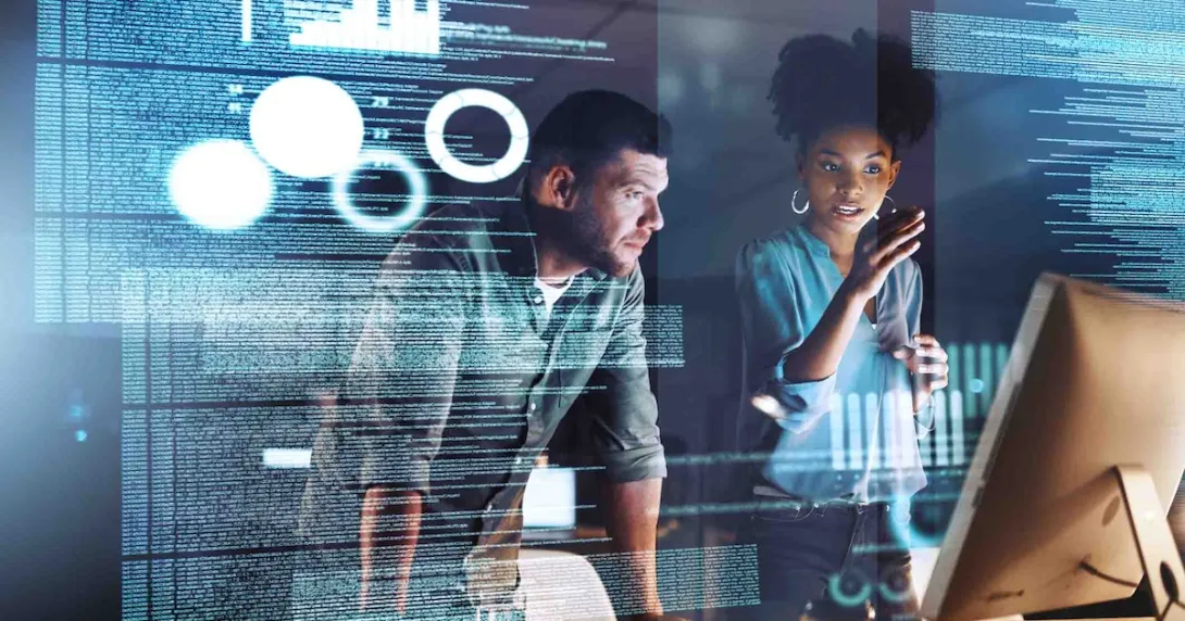 Two programmers working on code at night