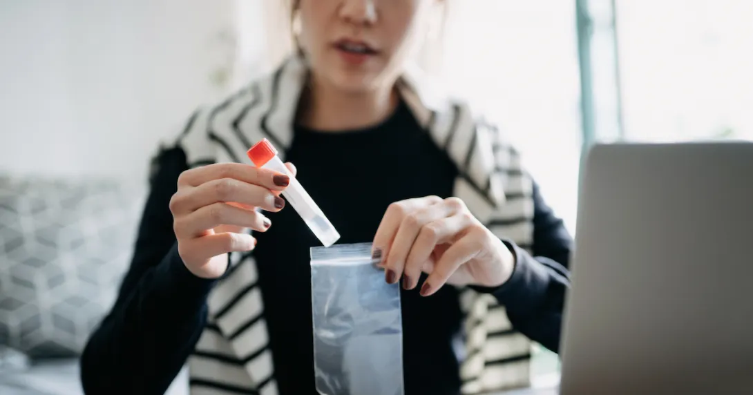 A woman putting a test sample in a bag to return in the mail.