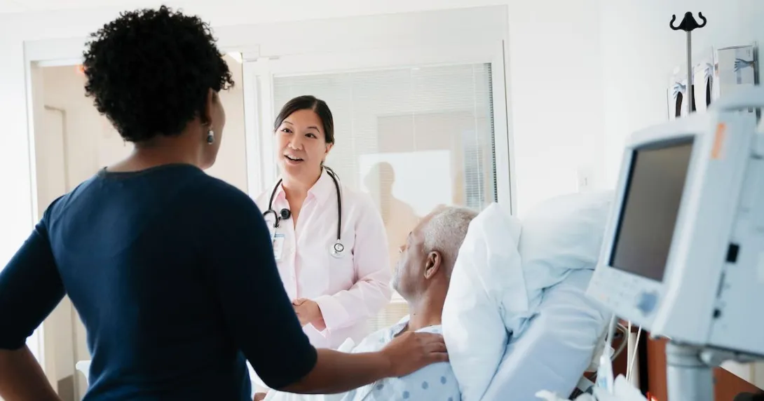 A doctor talking to patient and his family in a hospital room.