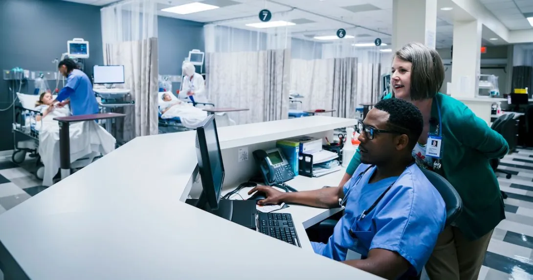 Providers using a computer in a hospital.