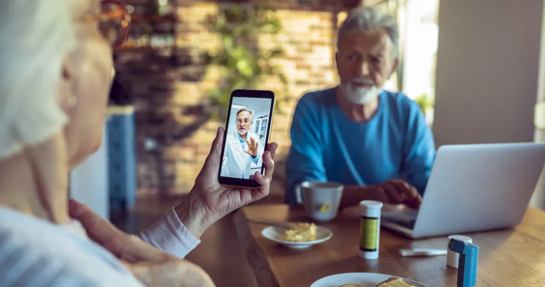 A couple talking on a smartphone telehealth visit