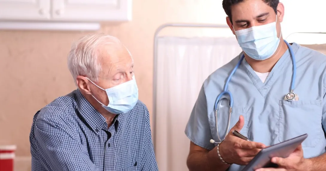 A medical professional with a tablet consults with patient