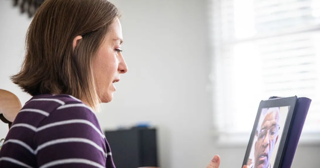 A woman talking to a provider through a video call on her tablet