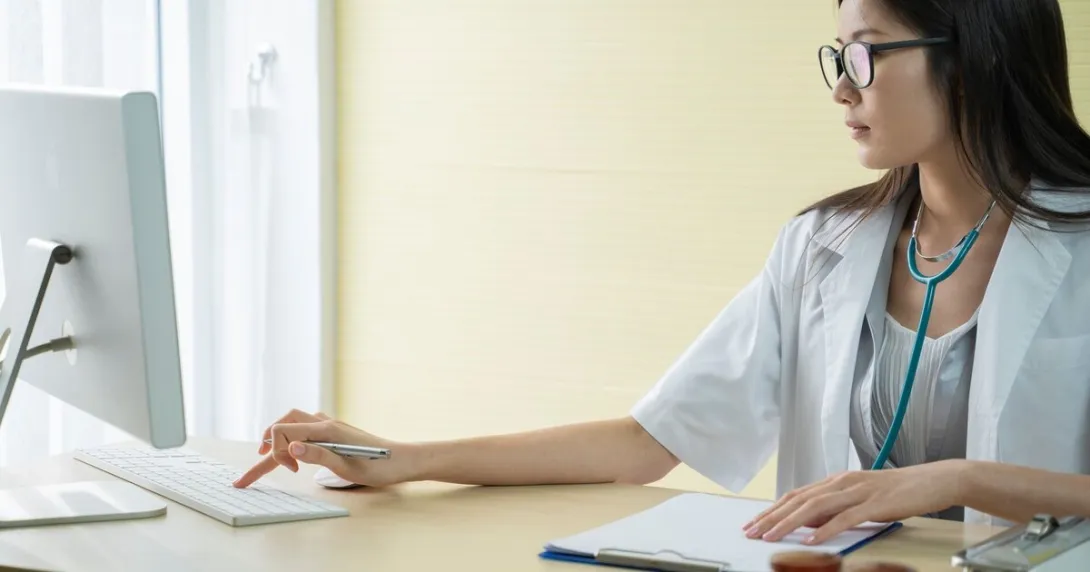 A doctor researching about a patient's condition using a desktop computer
