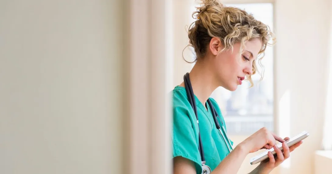 A nurse checking on their schedule in a digital tablet
