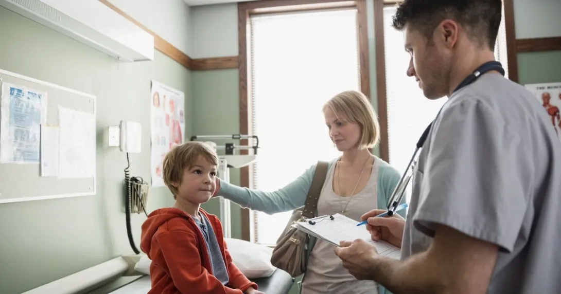 Healthcare provider with a patient and their caregiver in a clinic