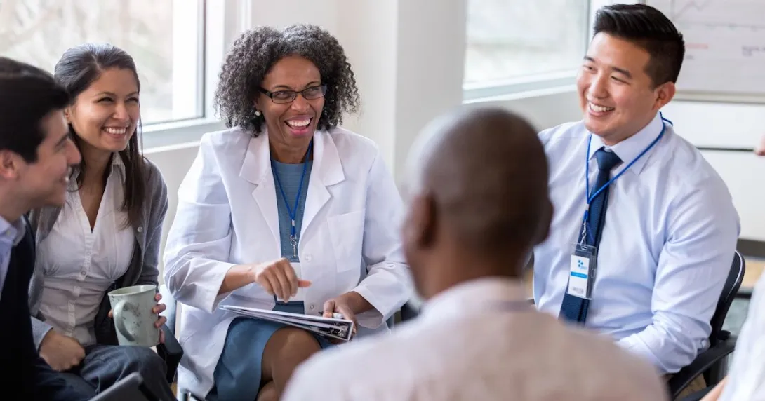 Five people sitting in a circle talking