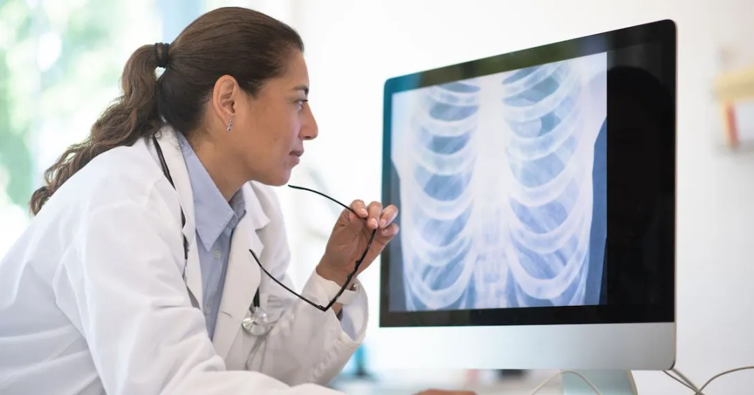 Healthcare professional looking at a computer screen with an x-ray on it