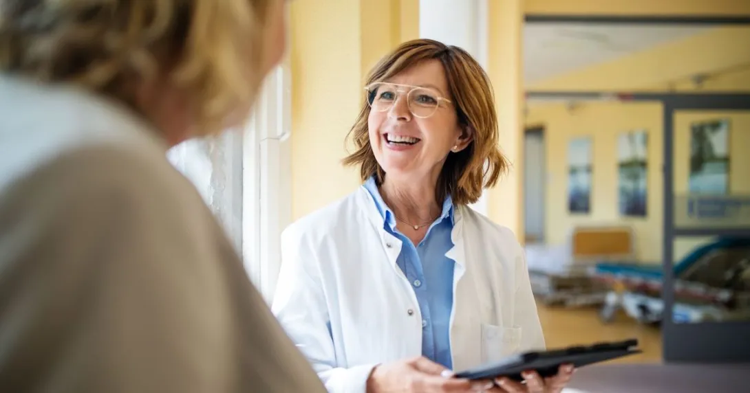 Healthcare provider speaking to a patient while smiling