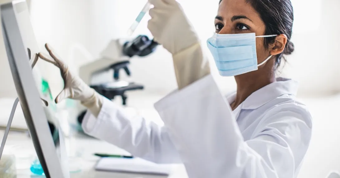 Scientist in a lab looking at a test tube