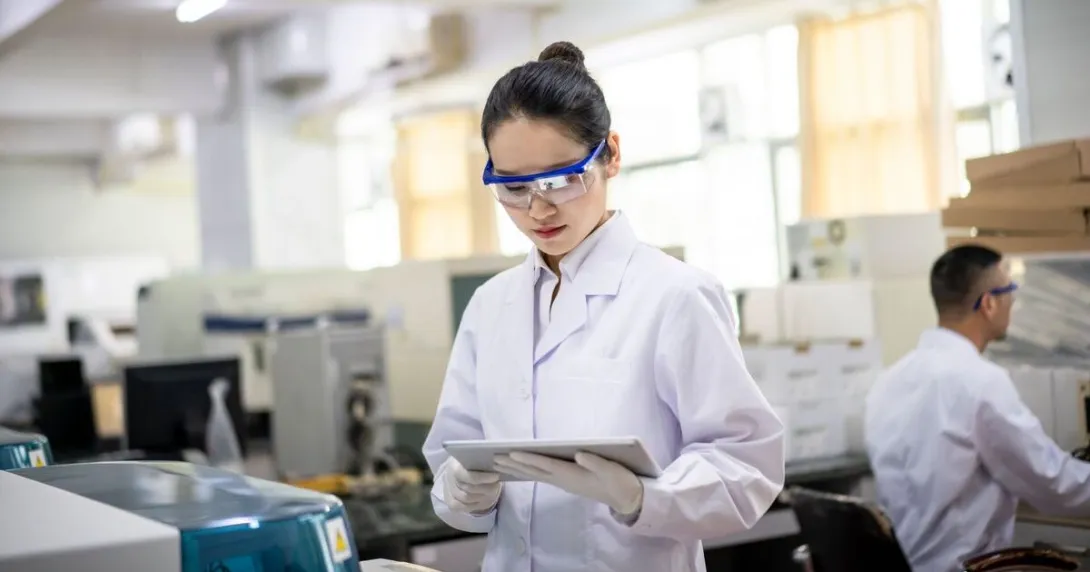 A researcher using a digital tablet in a laboratory.